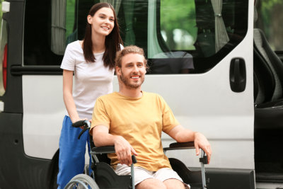 young woman helping young man on a wheelchair
